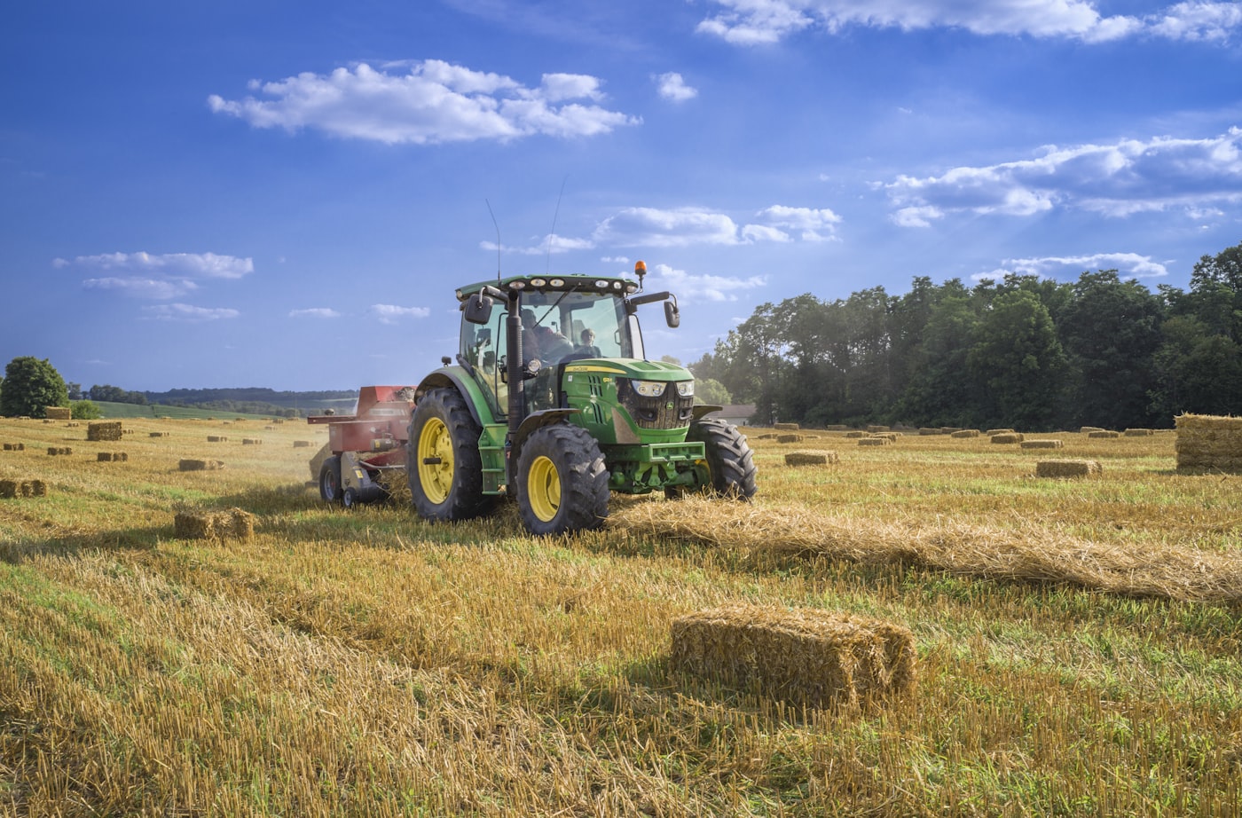 Tractor baling hay on farmland