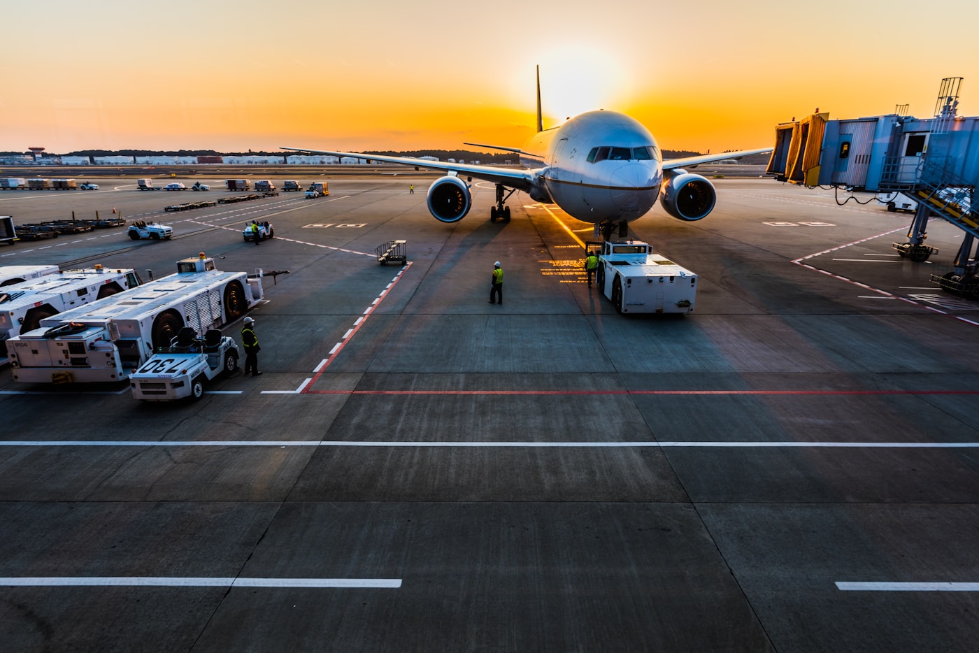 Passenger jet at an airport gate at sunset