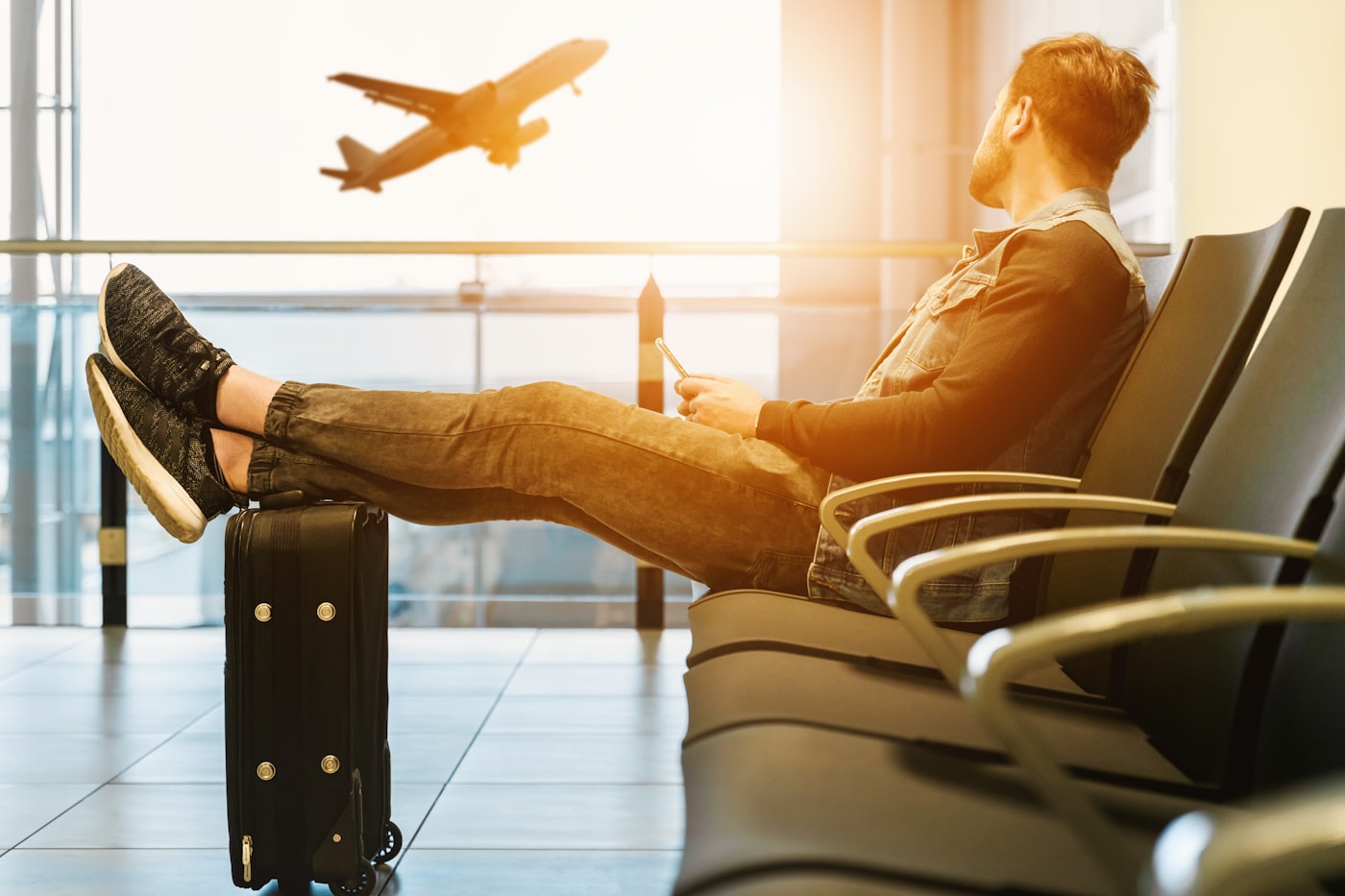 Traveller watching a plane take off from the terminal