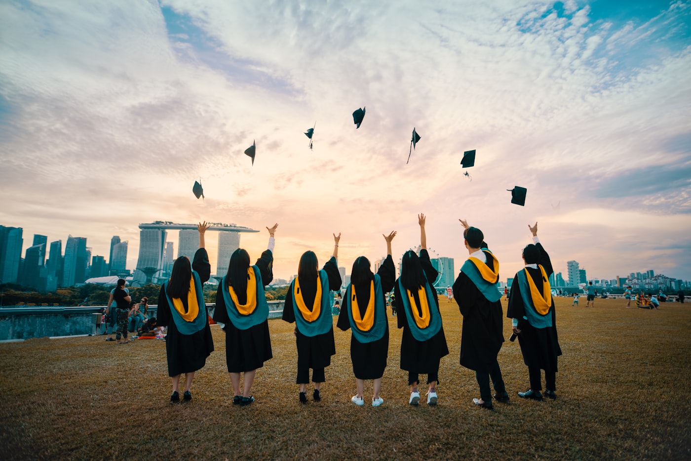 University graduates throwing their caps at sunset