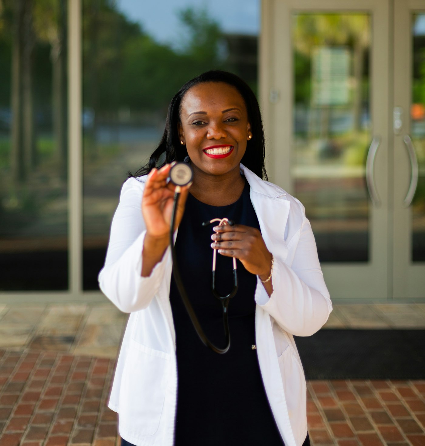 Smiling African doctor in a white coat with a stethoscope