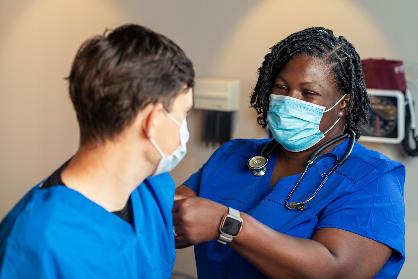 Two nurses in scrubs working together on a hospital ward